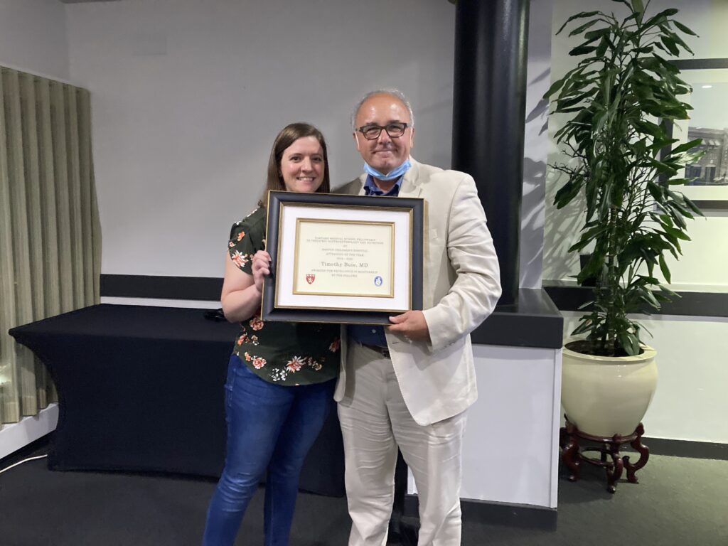 Two people holding framed award plaque